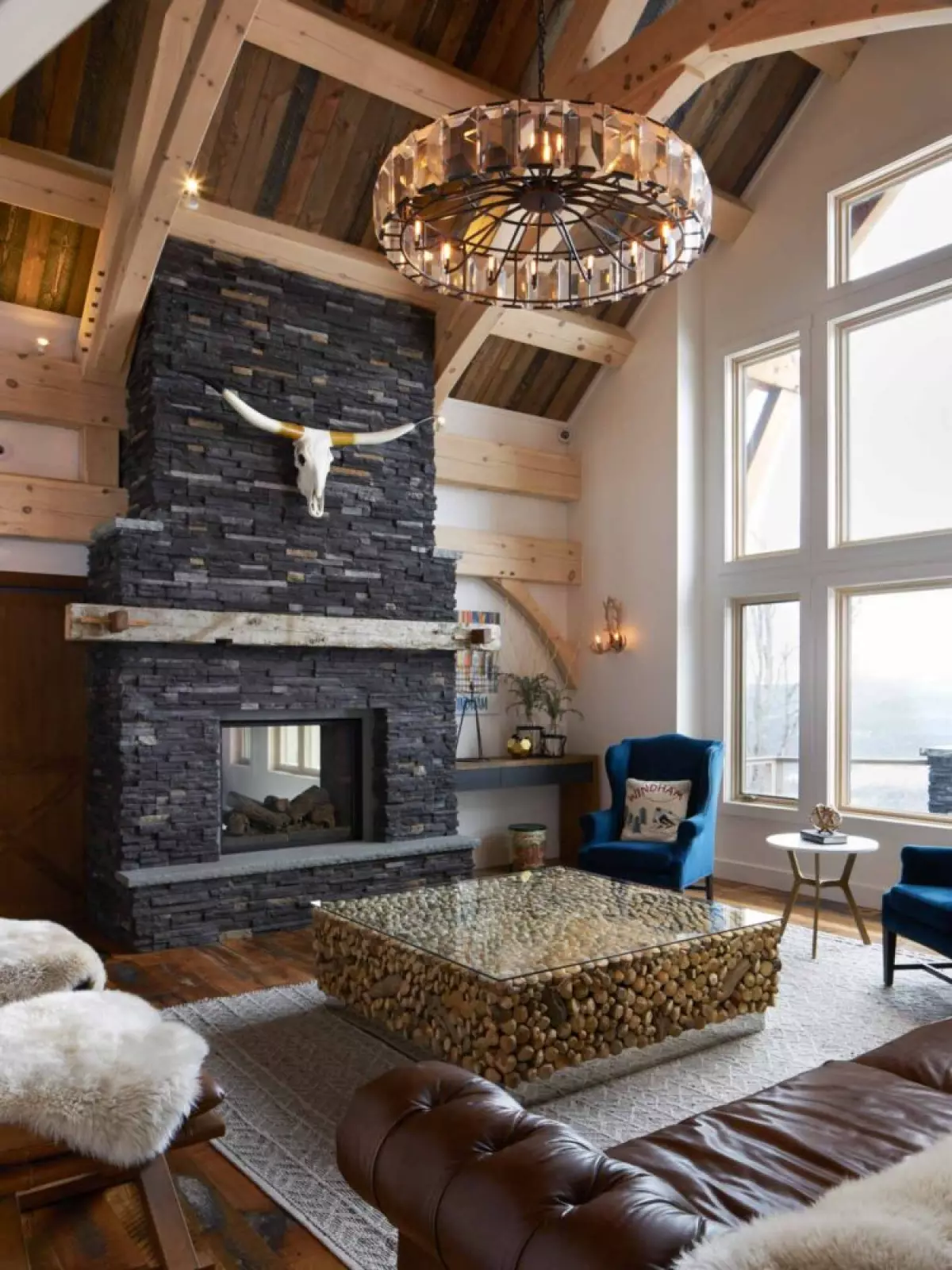 Mountain modern style great room with flagstone fireplace, kobalt blue chairs, glass coffee table