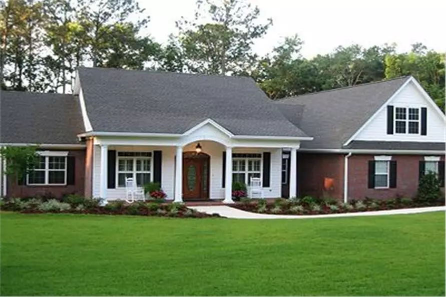 Symmetry in this Colonial style home: windows with decorative shutters on either side of the front door; rockers and planters on the porch that are balanced in numbers and positioning