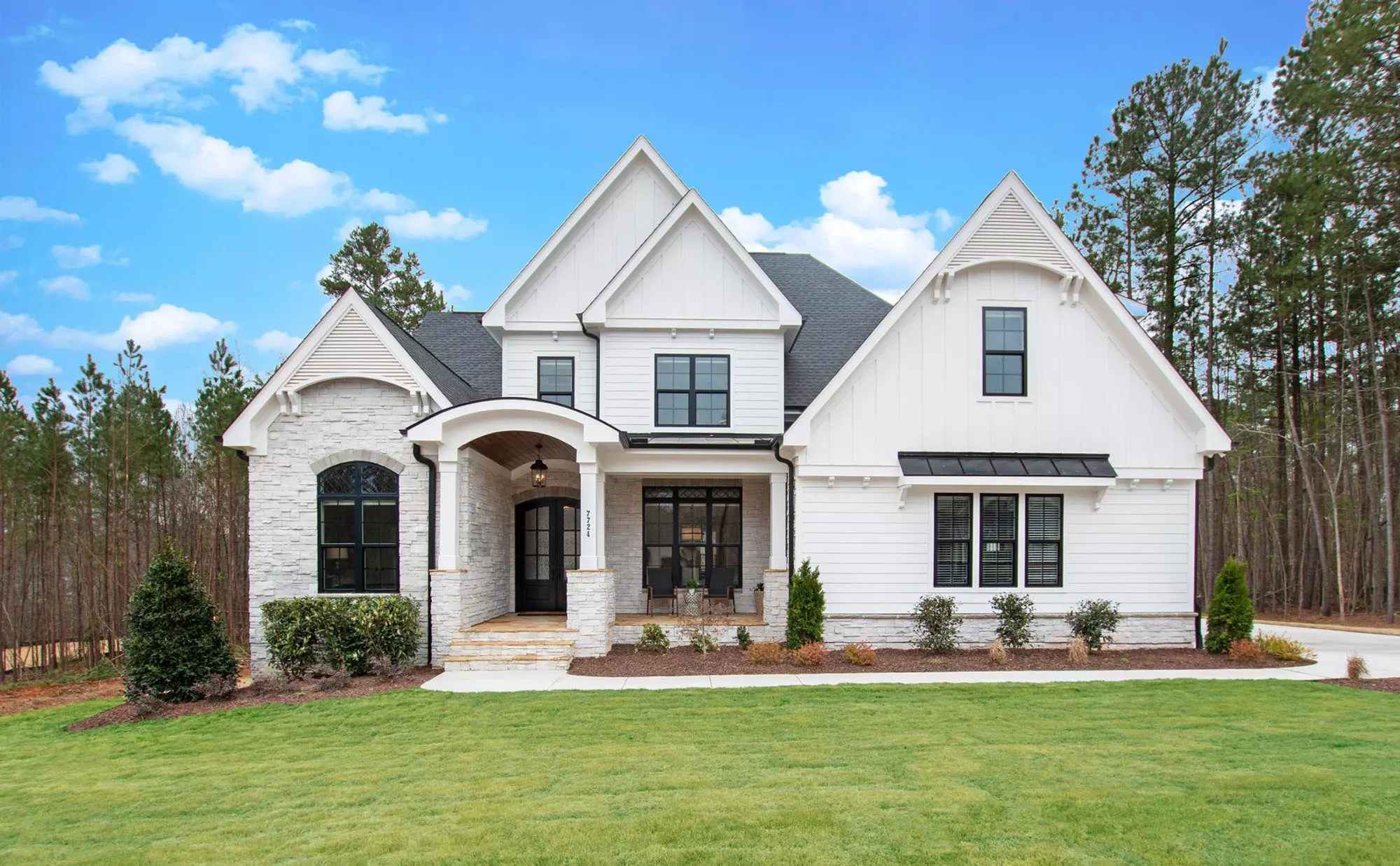 Beautiful modern farmhouse with an arched portico. Portico Designs.