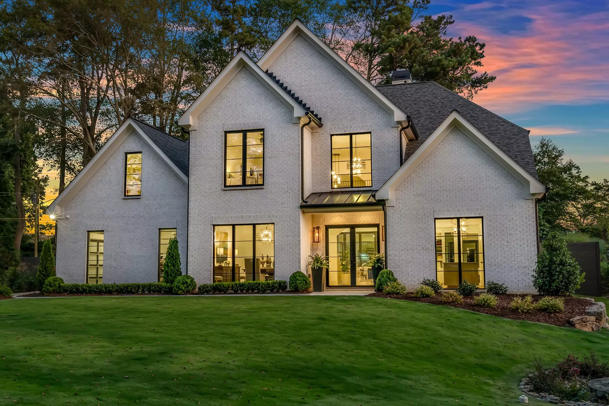 White brick house with a black metal shed style portico without columns. Portico Designs.