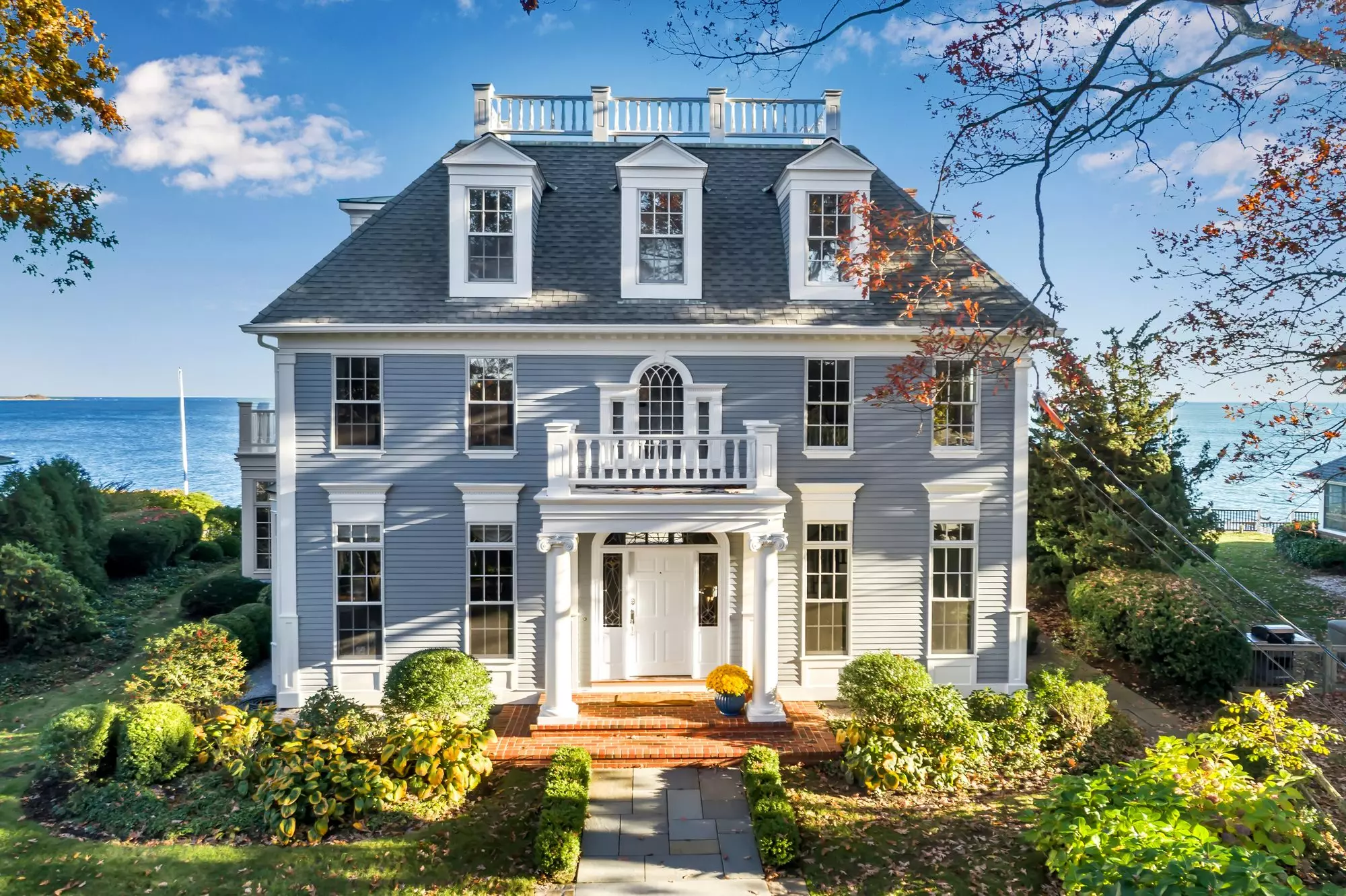 Classic flat roof balcony portico with round columns and railings.