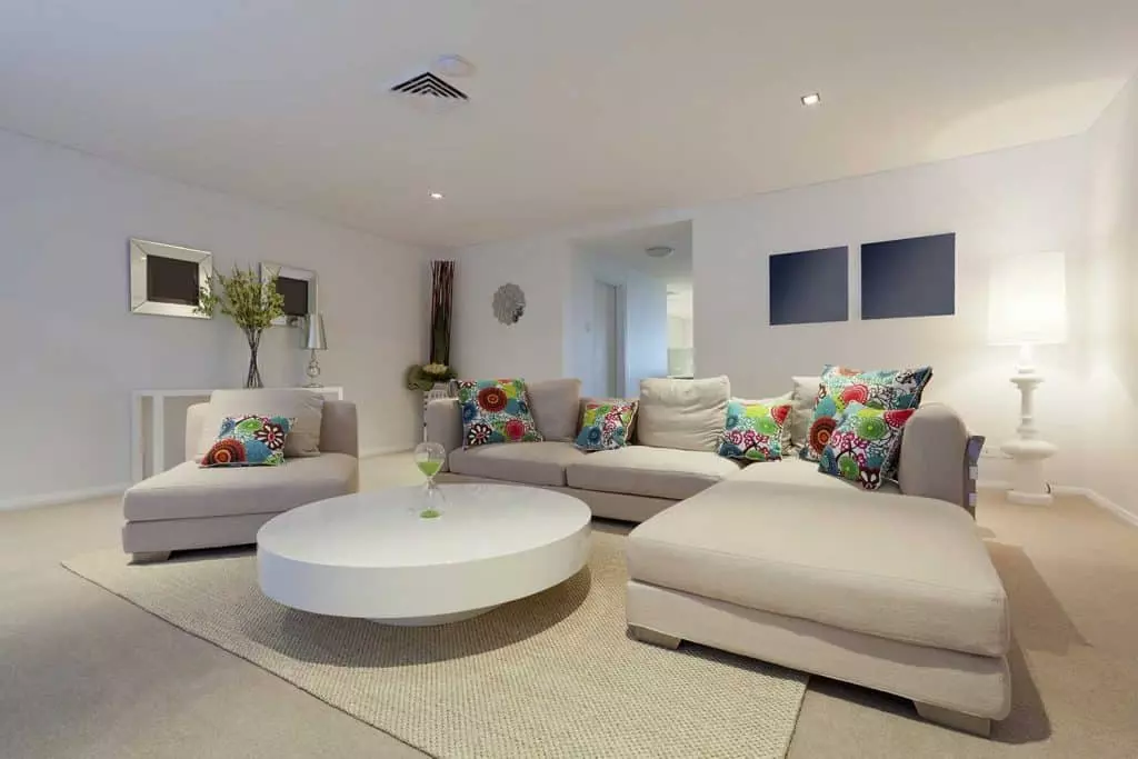 Modern living room with blue sofa and round table on carpet