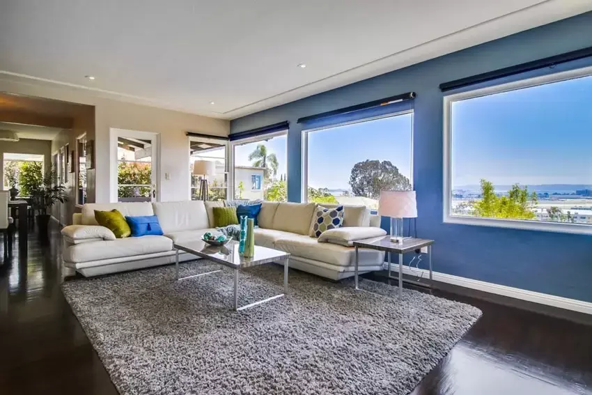 Contemporary living room with modern chandelier and navy blue accent wall