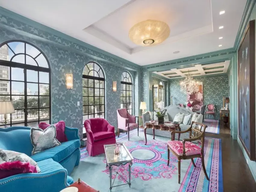 Living room with high vaulted ceilings with painted beams, fireplace, and lake views