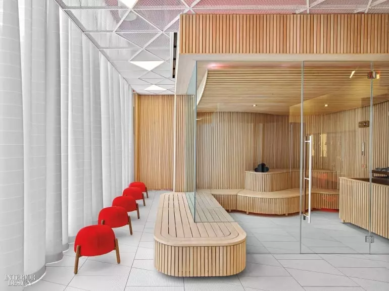 A man sits in a sauna lined with wood planks in this spa design