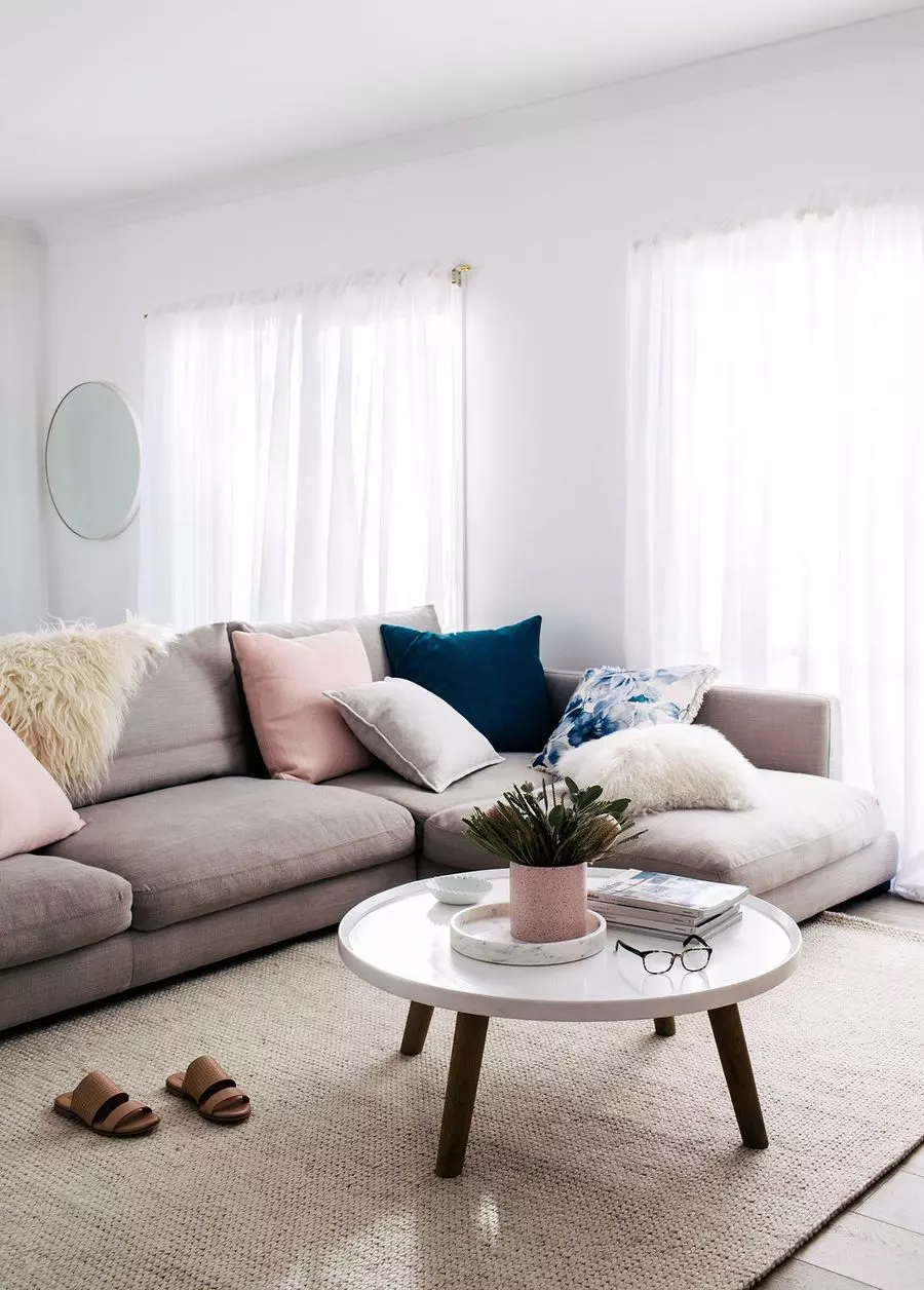 White Slipcovered Sofa and White Coffee Table in Scandinavian Living Room with Nordic-inspired design via entrancemakleri