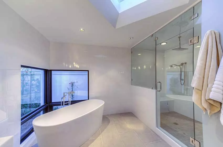 Modern bathroom with brown vanities and pendant chandelier over bathtub