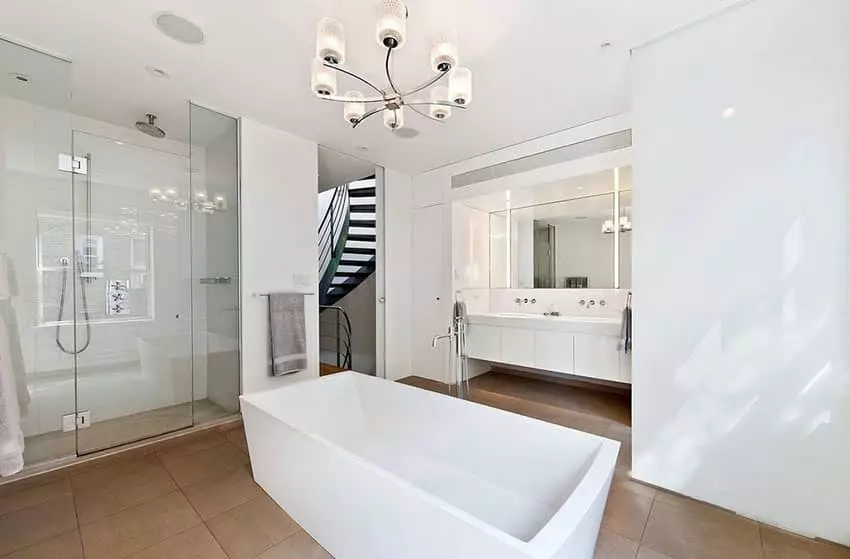 Modern bathroom with elevated freestanding tub and gold chandelier