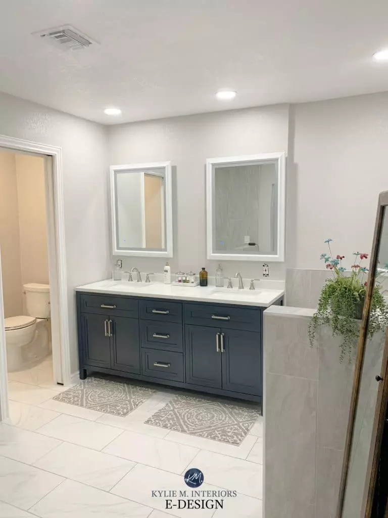 Navy blue vanity, Benjamin Moore Nimbus walls with warm gray tiles.