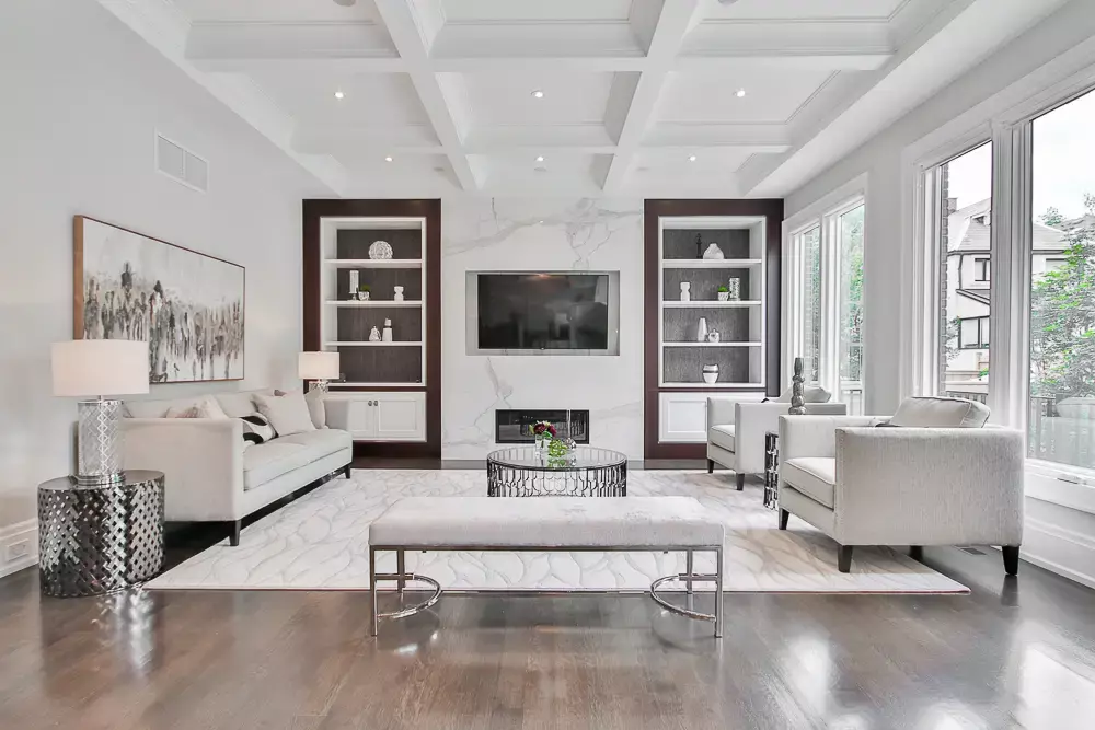 A neutral color family room with two sofas facing each other flanked by bookshelves