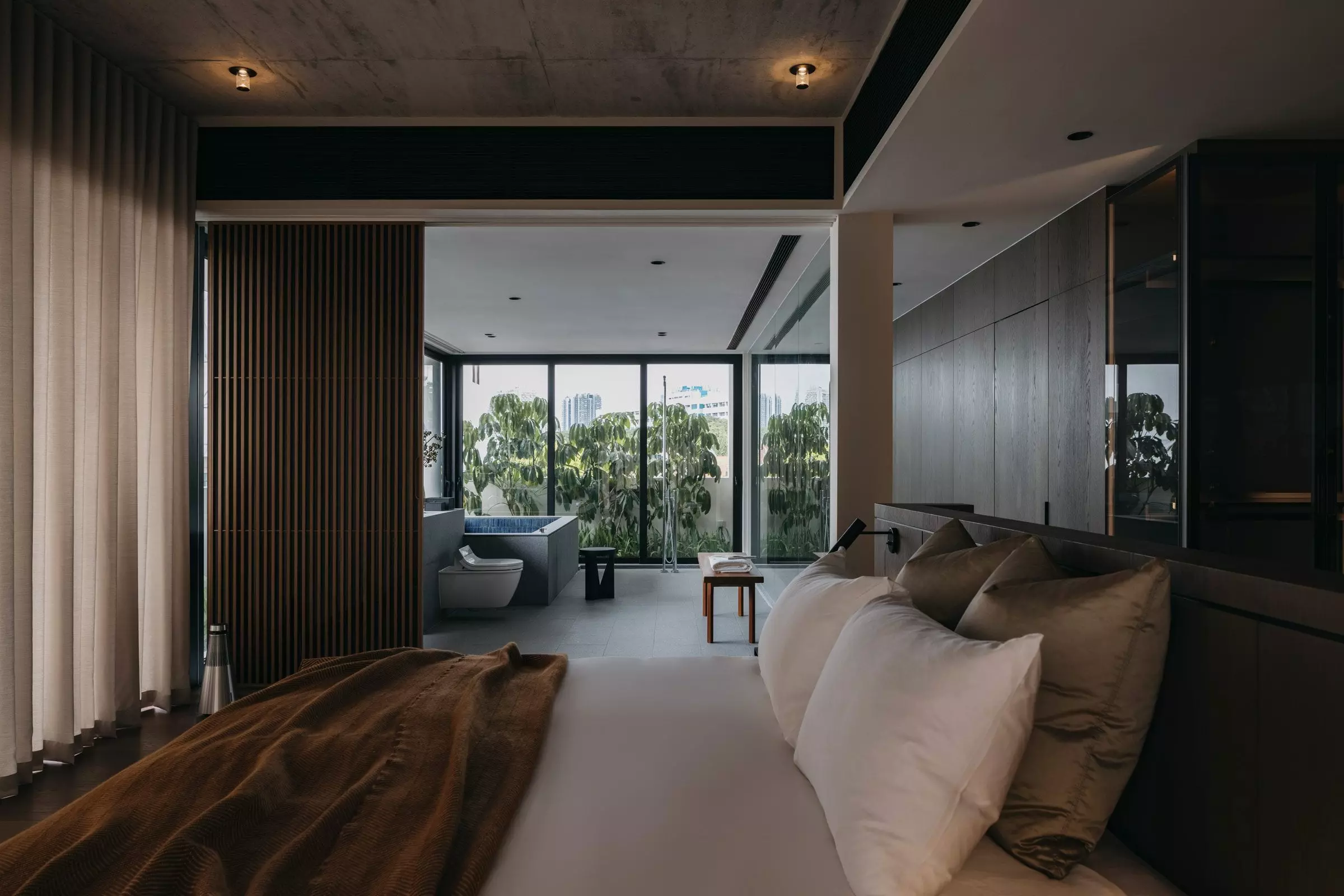 Moody Japanese bedroom design with a vertical wood slat room divider