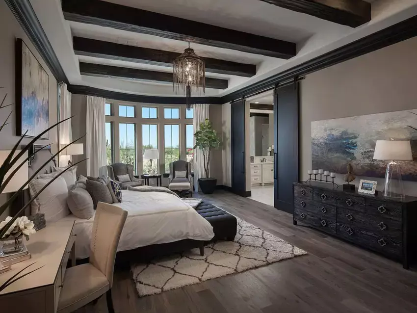 Masculine primary bedroom with brown paint, white built-in cabinets and leather headboard