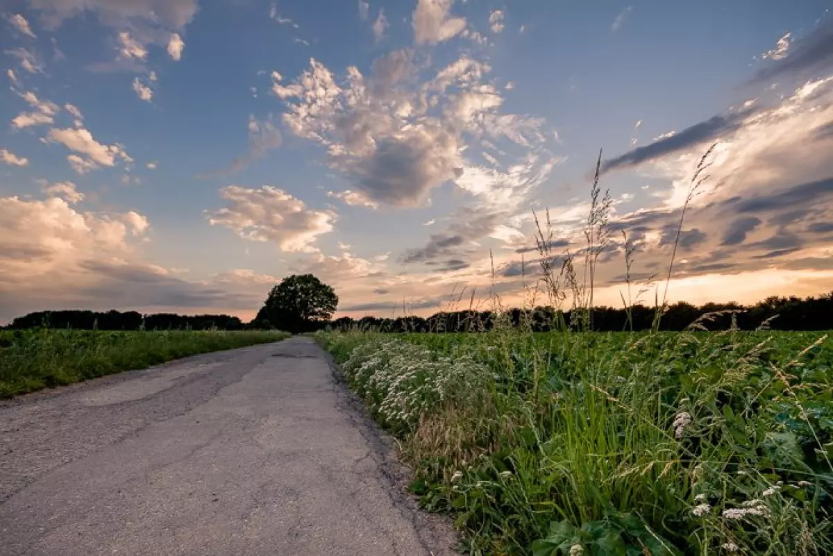 A compelling sunset over a countryside road and fields