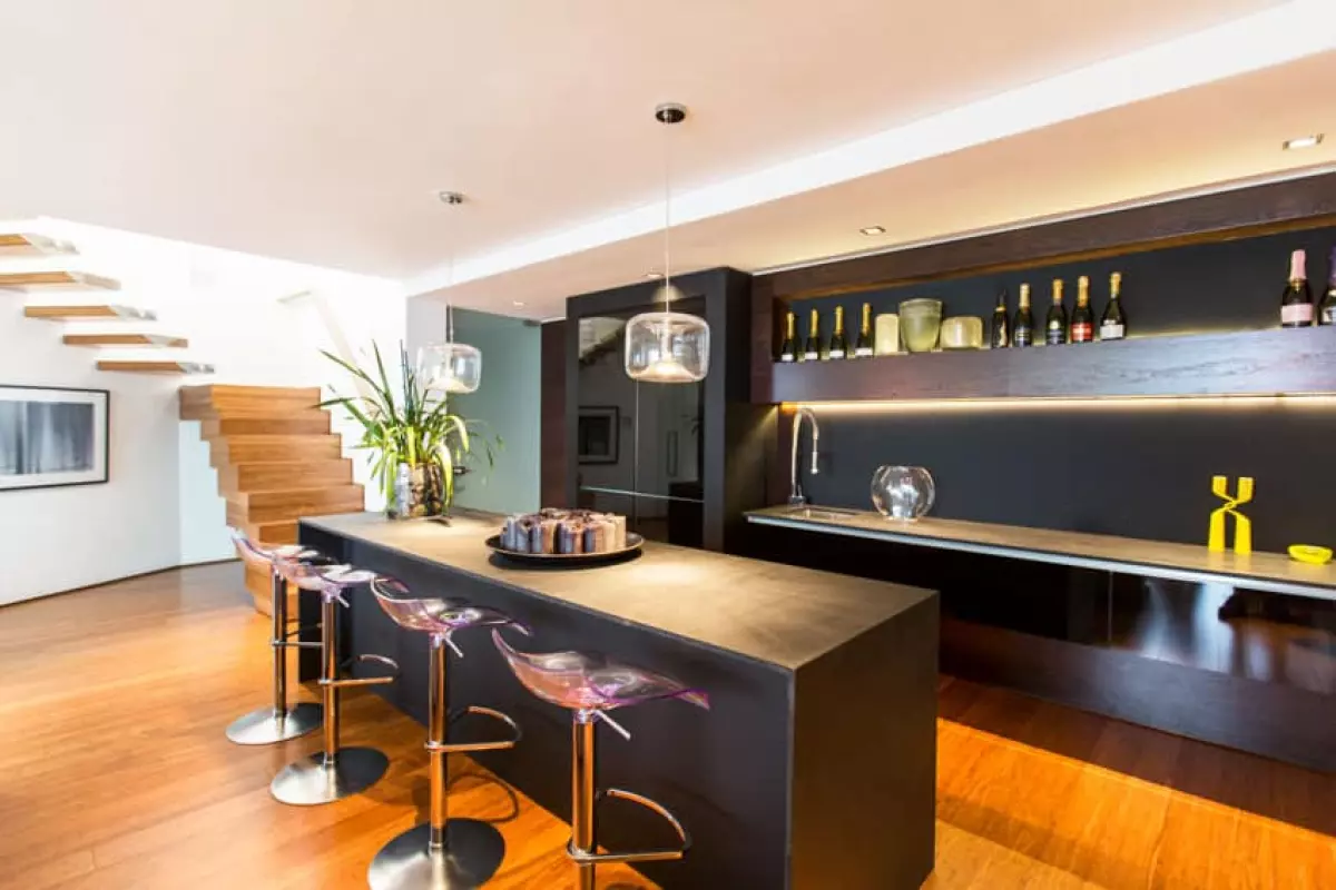 Basement bar with counter, stools, faucet and shelves