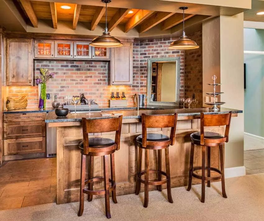 Kitchen with peninsula chairs, bar with sink, and pull out shelves