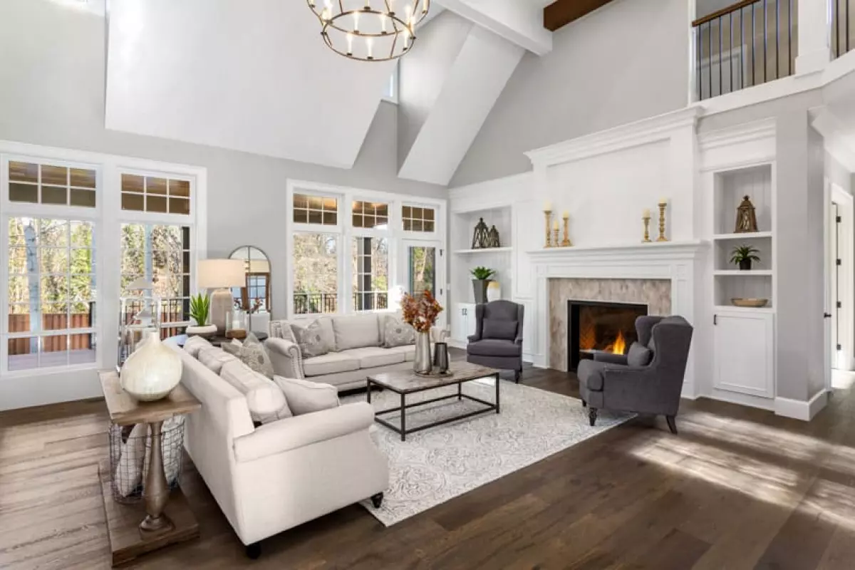 Living room with transitional sofa, coffee table, accent chair, windows, fireplace, sofa table, and wood floors