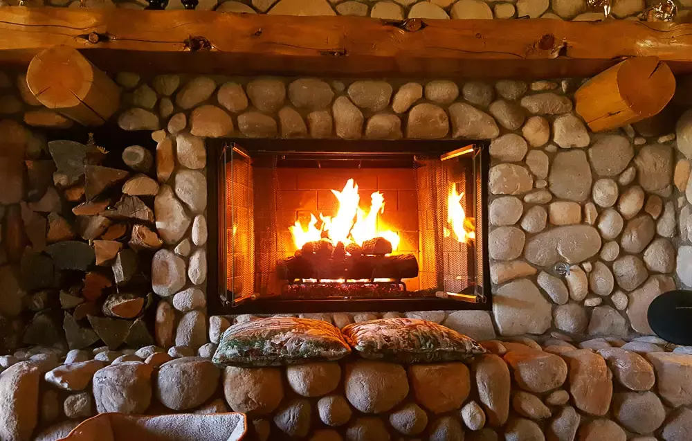 Cozy cobblestone fireplace with a blazing fire