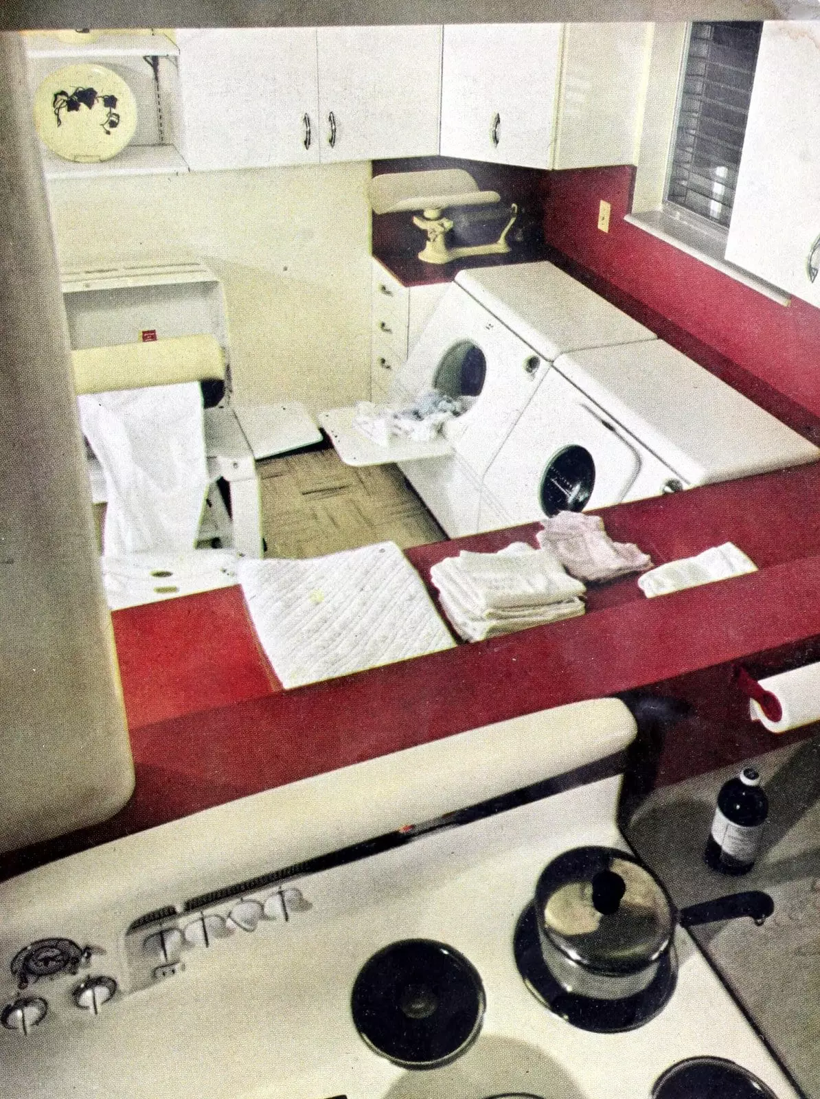 Old-fashioned washer and dryer in a 1950s retro laundry room with counter space (1952)