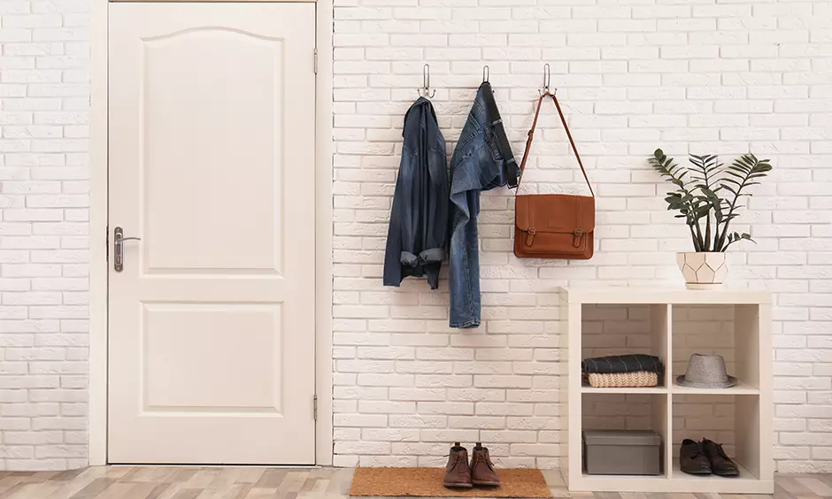 Modern entrance hall idea, foyer area design with yellow cabinet unit and painting on the wall lend an artistic vibe.