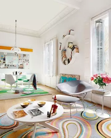 A living room with quirky blue and white walls and a funky table and chairs.