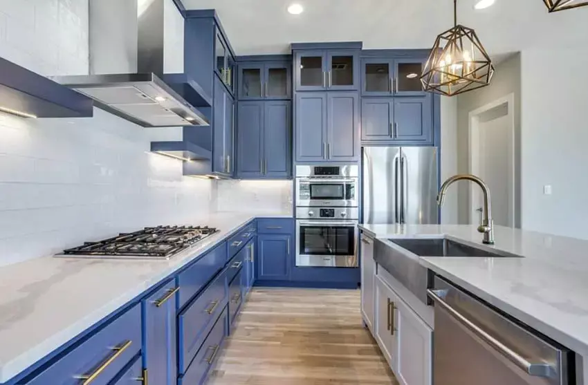 Kitchen with blue and white cabinetry and off-white quartz countertops