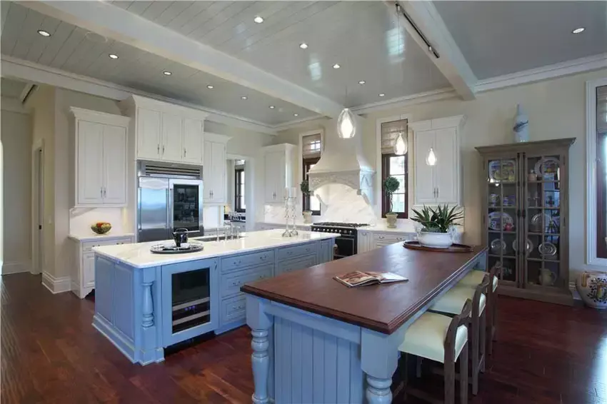 Kitchen with a blue painted kitchen with bi-level breakfast bar and red stools