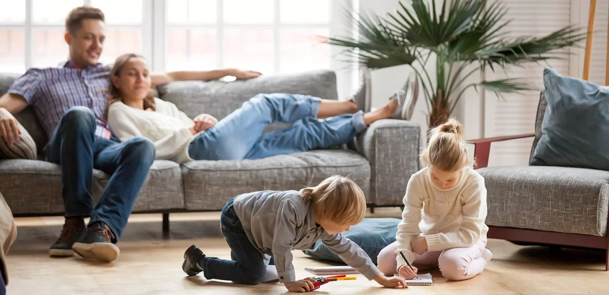 A family relaxing in the living room after finding an AC repairman