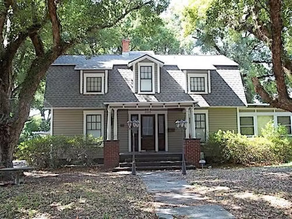 Dutch Colonial style home with shed and gable dormers