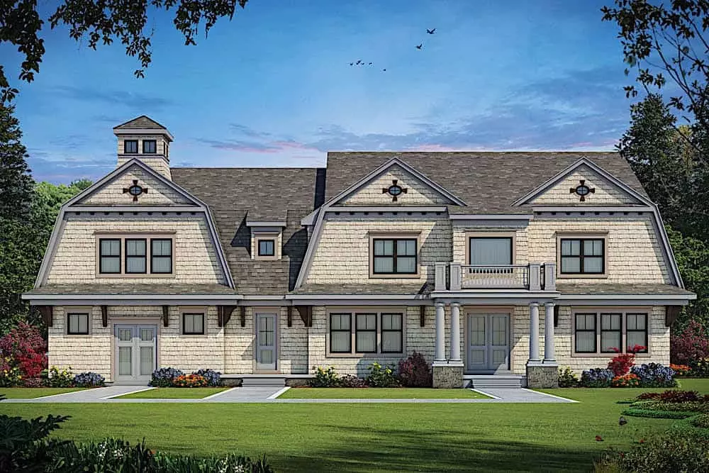 Dutch Colonial Revival house with stone and wood siding and attached 2-car garage