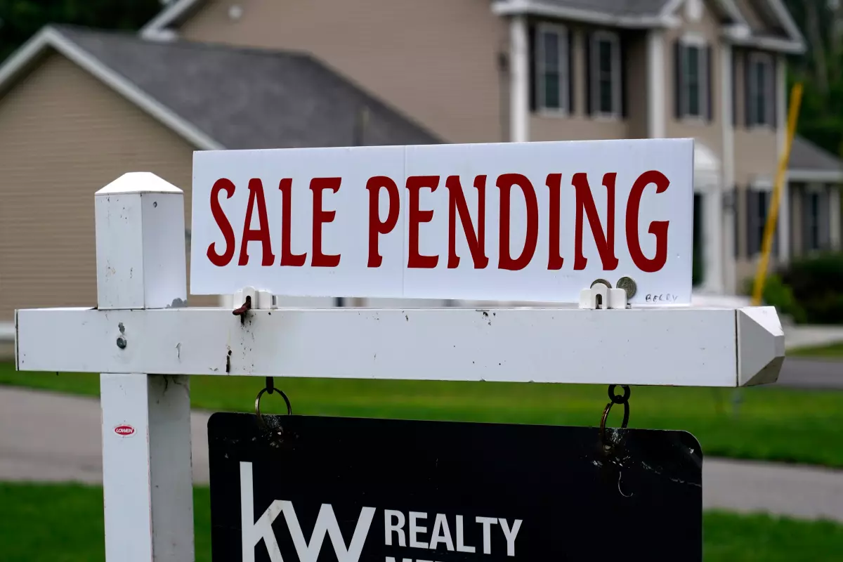 A "sale pending" sign is posted outside a single-family home in Derry, New Hampshire.