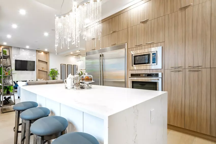 Kitchen with multi-colored laminate cabinets, pendant lights, and wooden floor