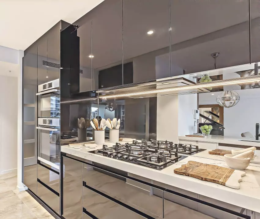 Kitchen with white laminate cabinets, floating shelves, and large island with elevated wood counters