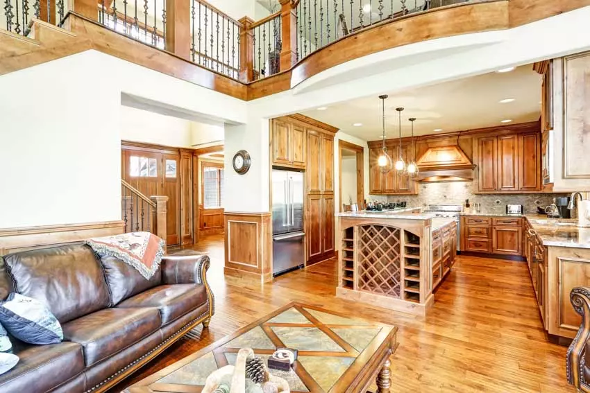 Kitchen with maple cabinets, center table, window, countertops, backsplash, oven, sink, and faucet