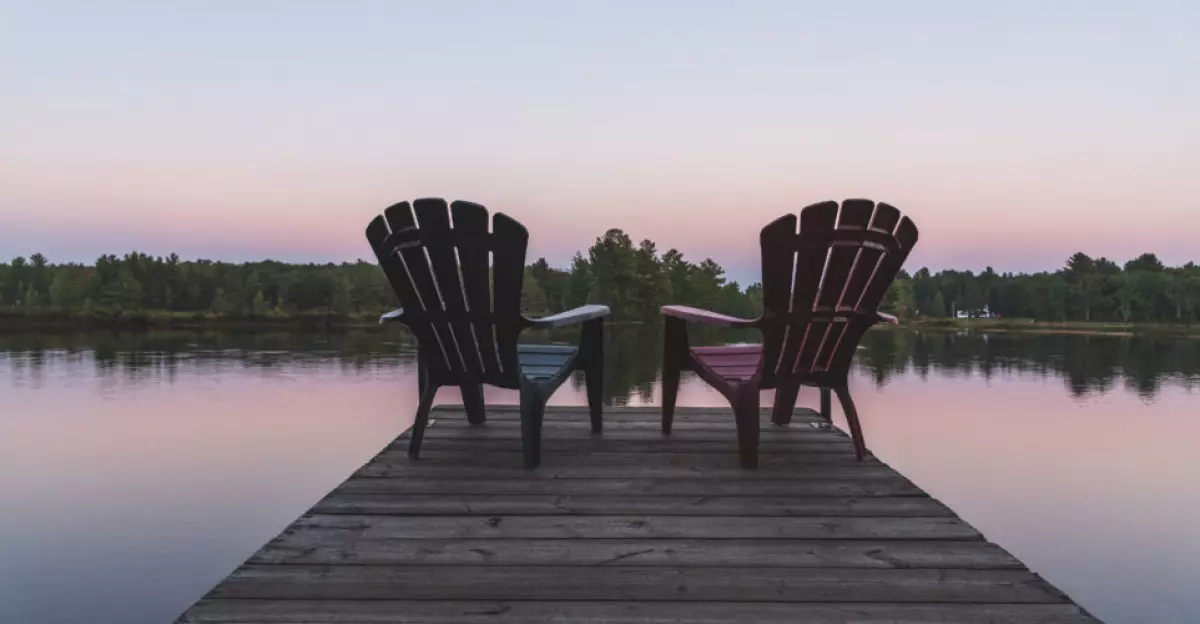 Two Adirondack chairs sitting on a dock - Muskoka, Ontario, Canada.