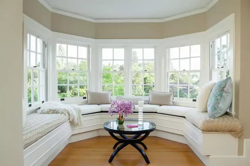 Bay window seat with comfy cushions and wood table