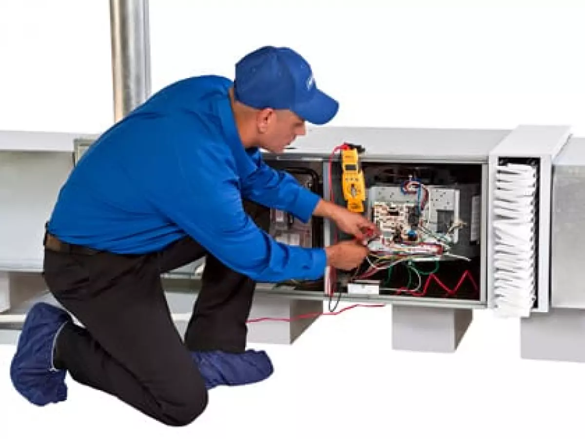 Technician servicing AC system.