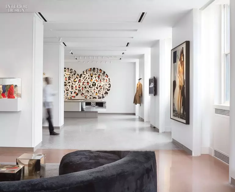 a leaf-like installation hangs from the ceiling in a green accented lobby