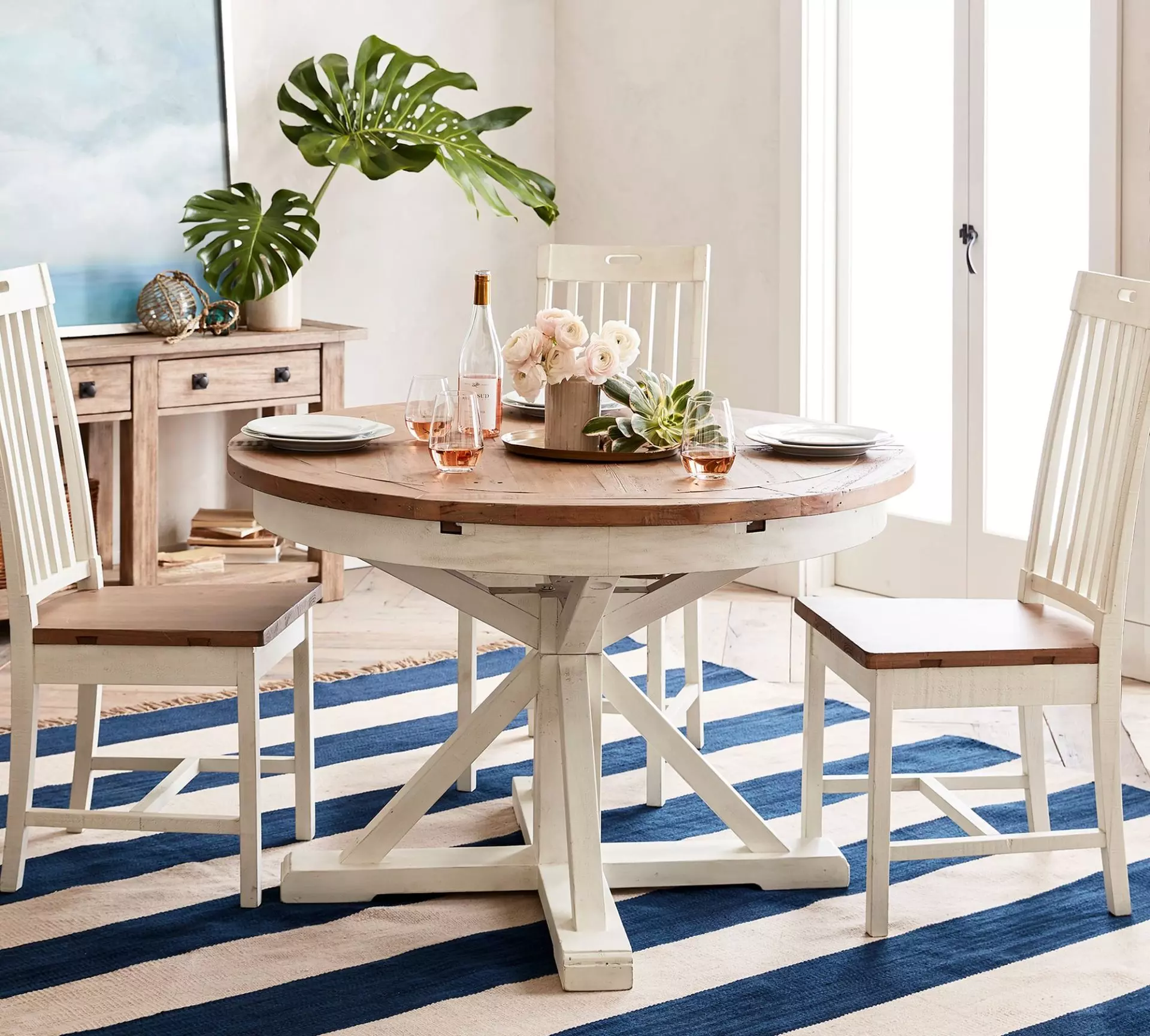 round wood dining table that can seat up to 6 guests.