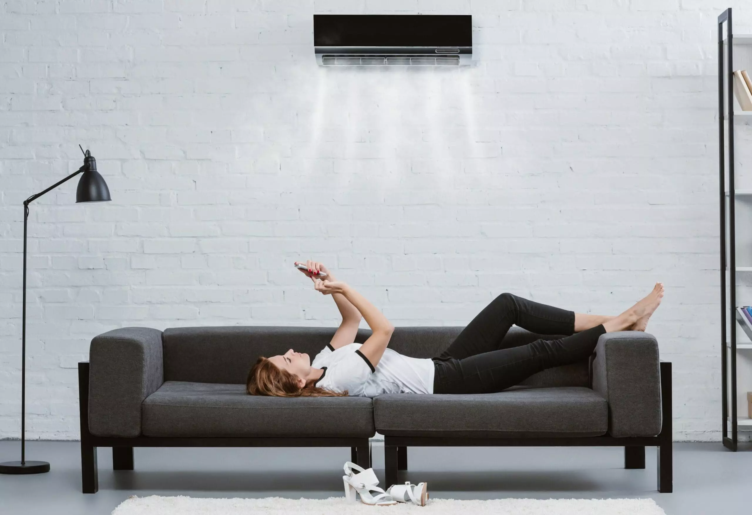 Woman holding phone with running smart home application for air conditioning