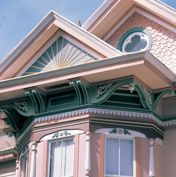 Polychromy calls attention to a sunburst, a quatrefoil, irregular shingles, brackets, and sawtooth ornament.