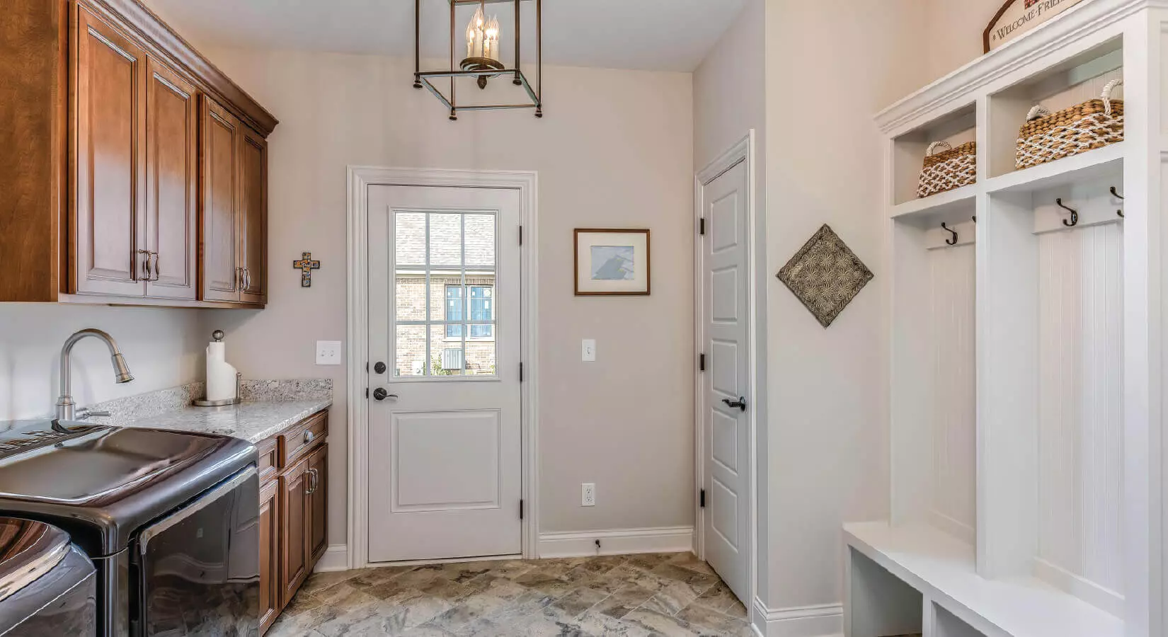 Laundry room with white beadboard cabinets, rolling laundry bins, and blue rug.