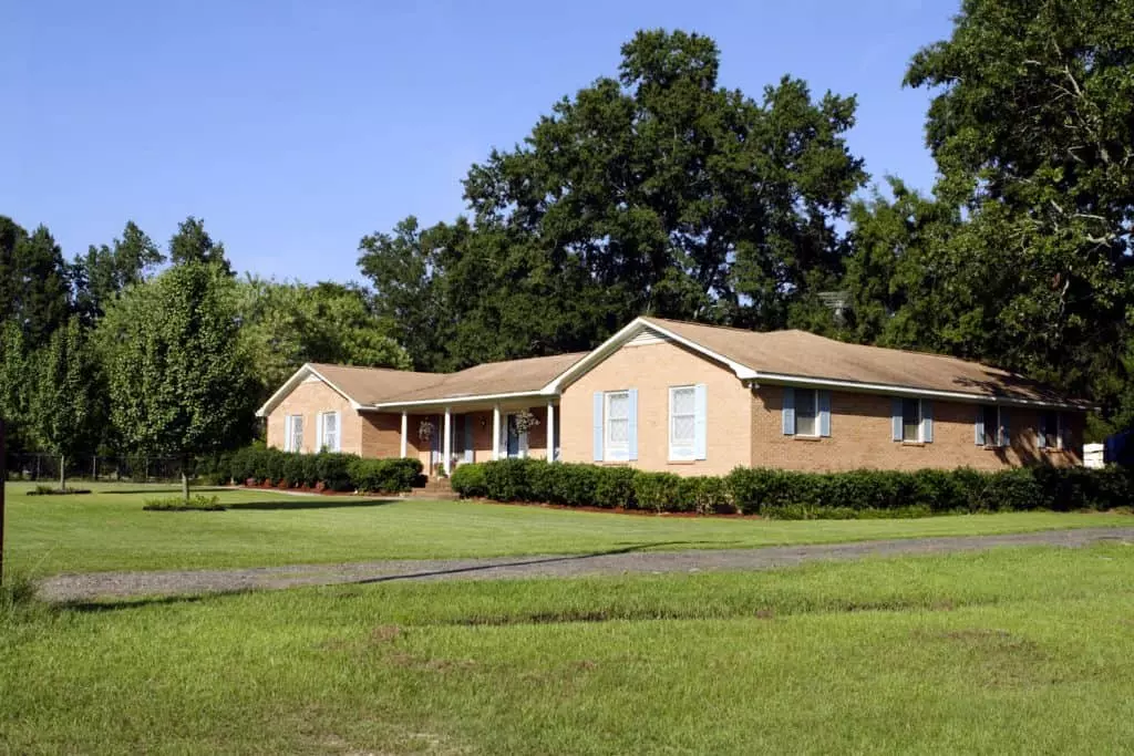 A modern styled ranch house with black painted wood siding and asphalt shingle roofing