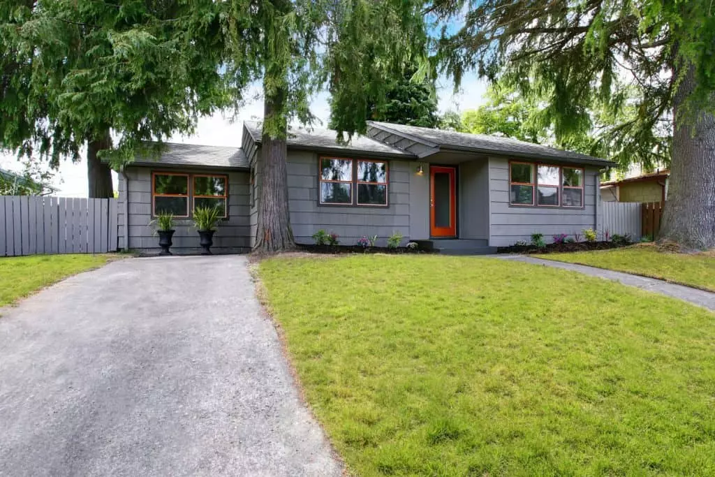 Stunning gray single-storey ranch house with polished windows, orange front door, and gray roofing