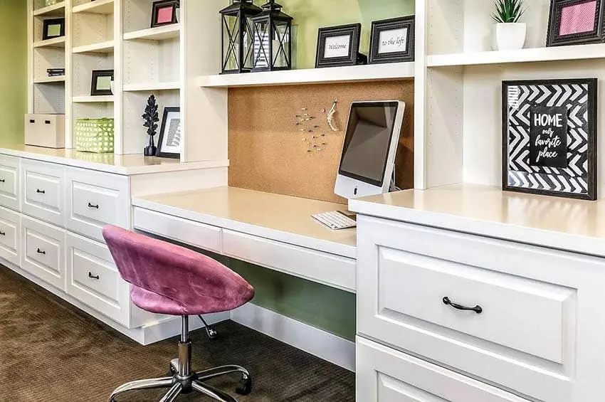 Office with multiple computer monitors on a long desk