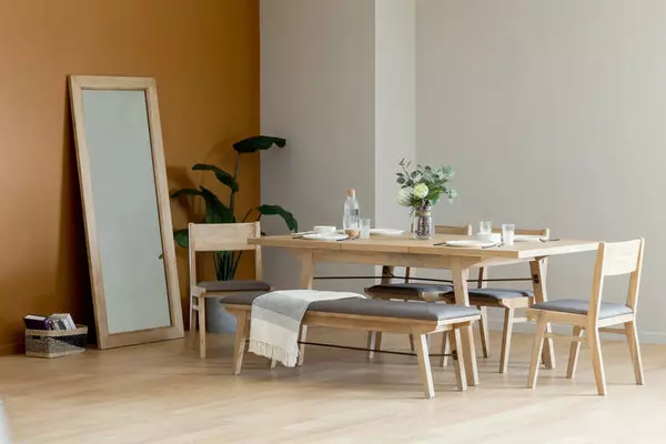 The Miles Mirror directly faces the Miles Extendable Dining Table with a Bench and Chairs.