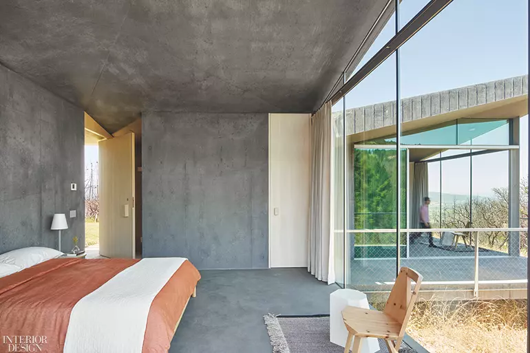 A gray bedroom with wood beam ceilings painted white