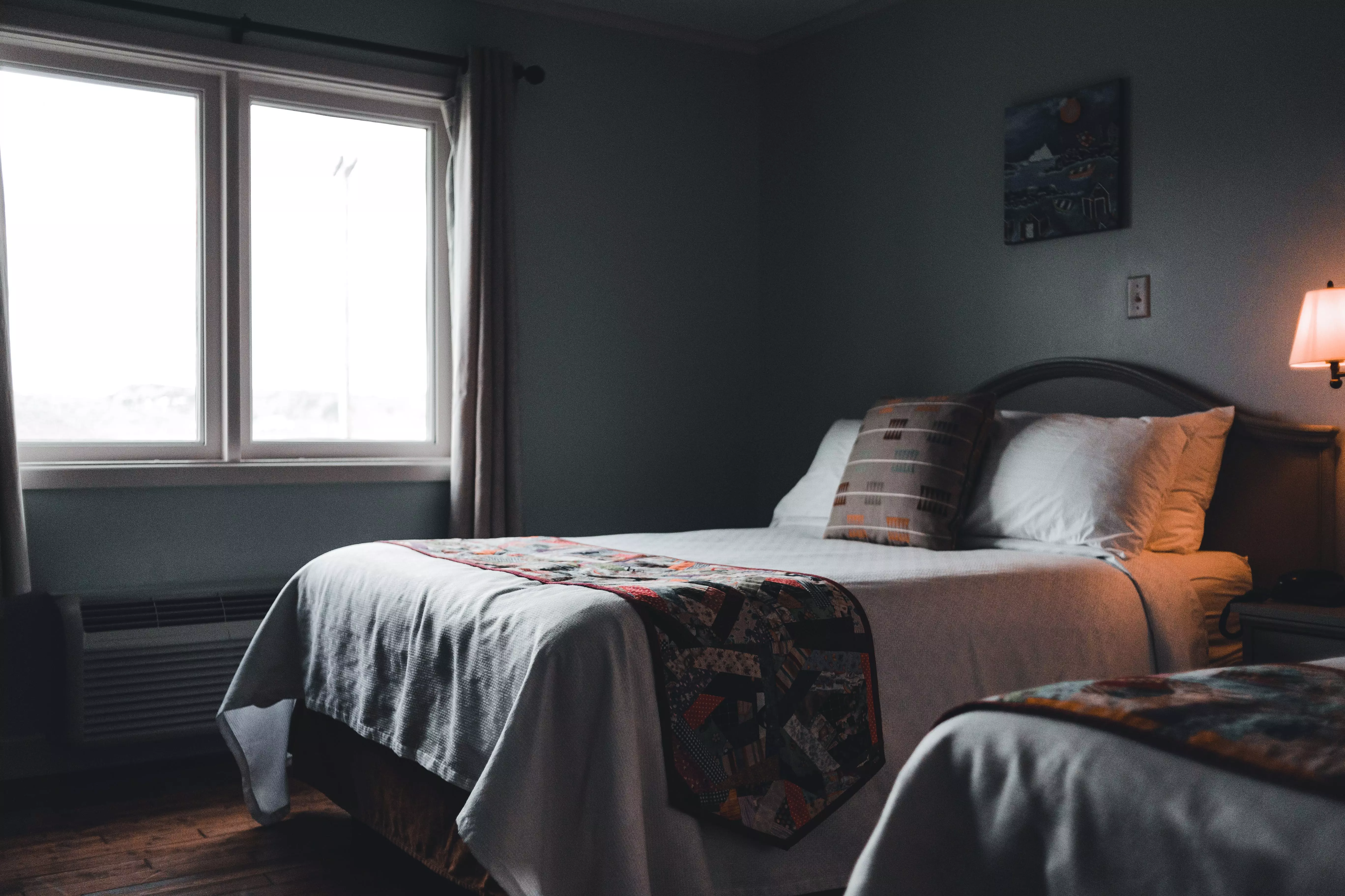 A Bed with Gray Bed Sheets and Pillows Near the Glass Window