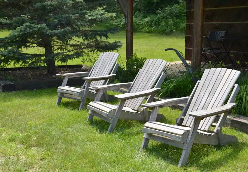 Outdoor area with four wooden Muskoka chairs arranged in a circle