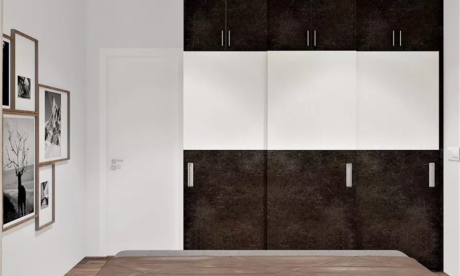 Simple 3 door wardrobe design in dark brown and white color combination lends a cozy vibe to the bedroom.