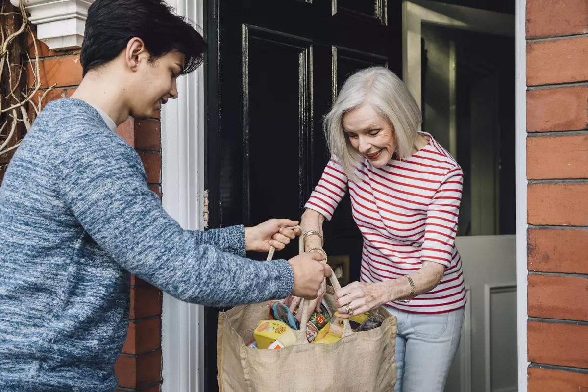 boy helping elderly women with groceries